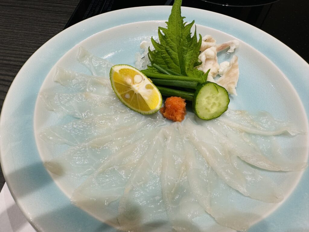 透ける薄切りのふぐ刺し(てっさ)と、すだち・もみじおろし・薬味の盛り合わせ