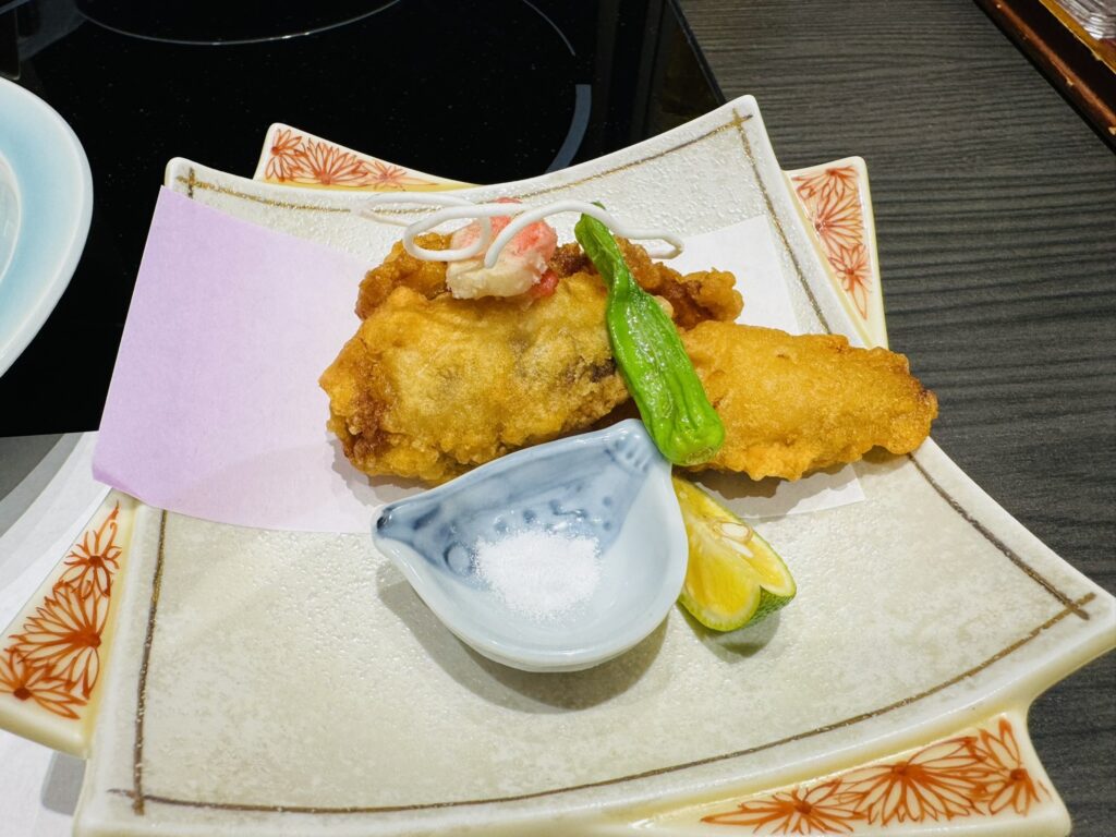 ふぐの唐揚げと塩、すだち、ししとうがのった皿