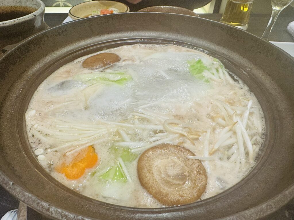 野菜ときのこを入れて煮立つしゃぶしゃぶ鍋(えのき、白菜、しいたけなど)