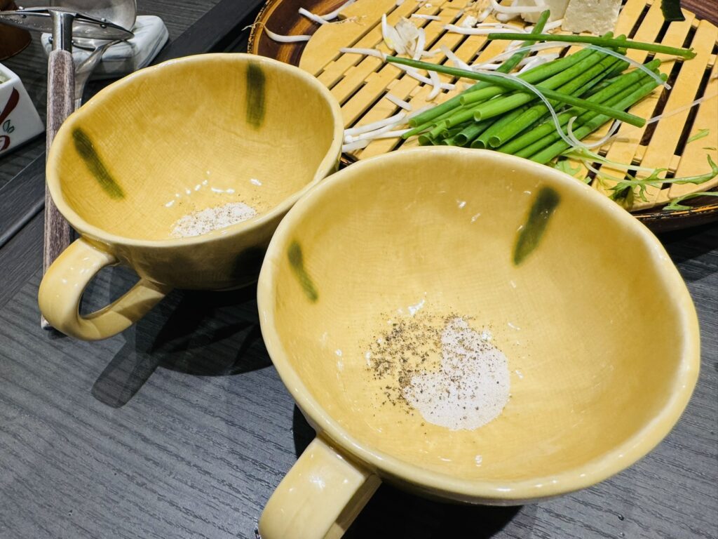 塩と胡椒を入れた黄色い器が2つ並ぶ(だしスープ用の味付け)