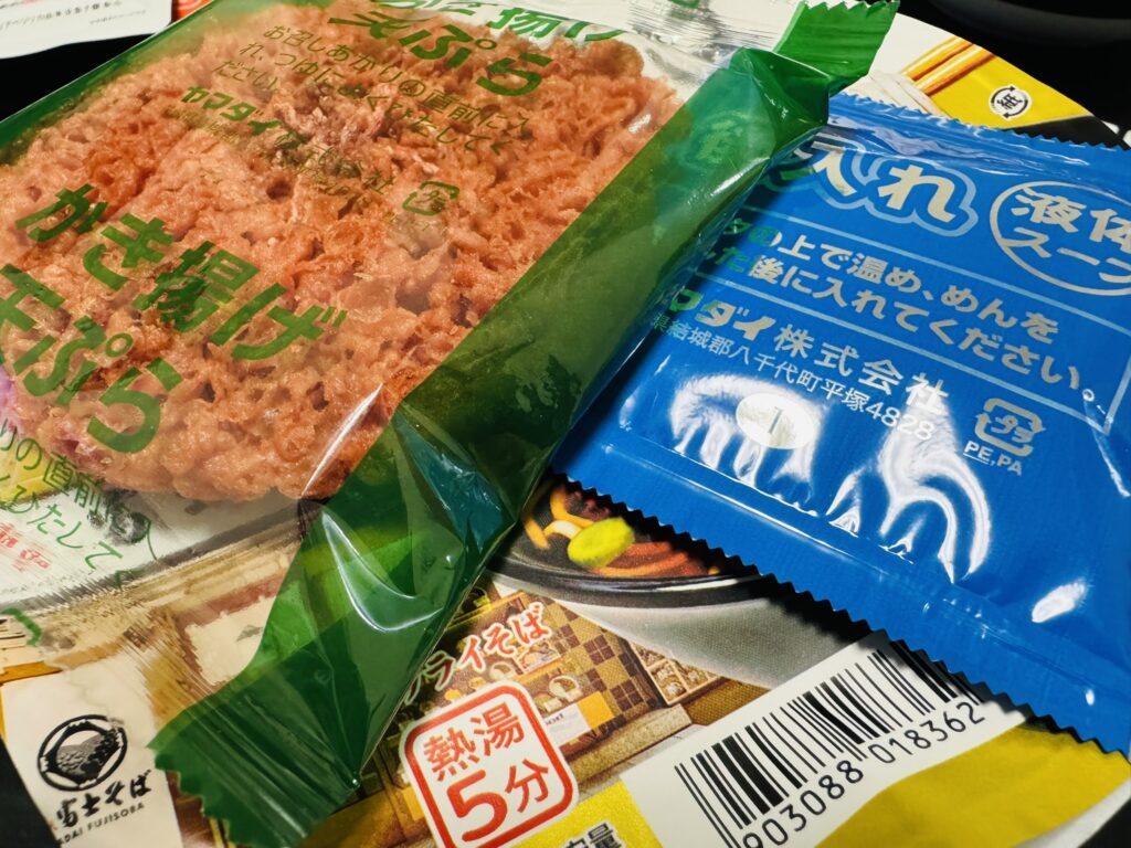 小袋のアップ。『後入れ液体スープ』の注意書きや、天ぷら系の袋が写っている。