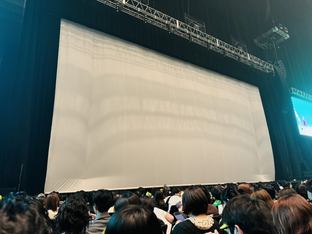 開演前のステージに大きな幕が下りている様子（客席から撮影）